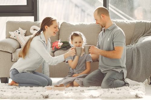 A joyful family enjoying quality time and coffee in a bright living room, symbolizing love and togetherness.