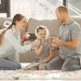 A joyful family enjoying quality time and coffee in a bright living room, symbolizing love and togetherness.